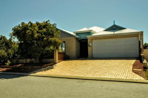 a house with a brick driveway and a garage at Halls Head Holiday Home in Mandurah