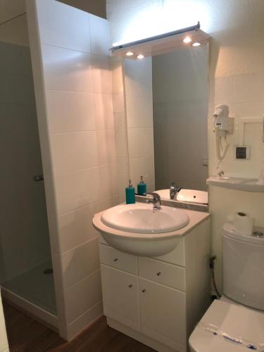 een badkamer met een wastafel, een toilet en een spiegel bij TEC CONFORT in Pas de la Casa