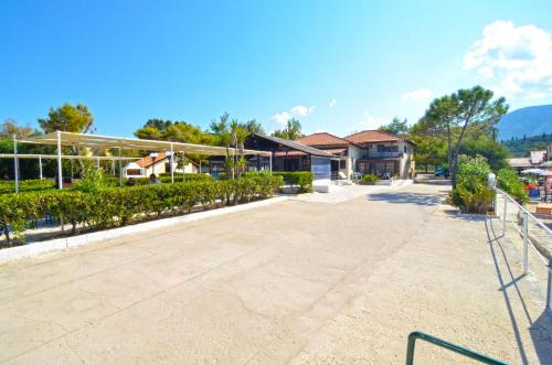 an empty parking lot in front of a building at Oasis Beachfront Studios & Apartments, by ZanteWize in Alikanas