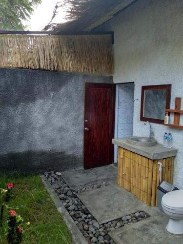 a bathroom with a sink and a toilet in a room at Edelweiss Homestay in Kuta Lombok