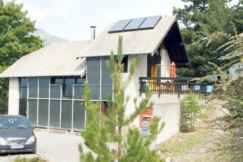 une maison avec des panneaux solaires sur le toit dans l'établissement Maison CAILLE, à Embrun