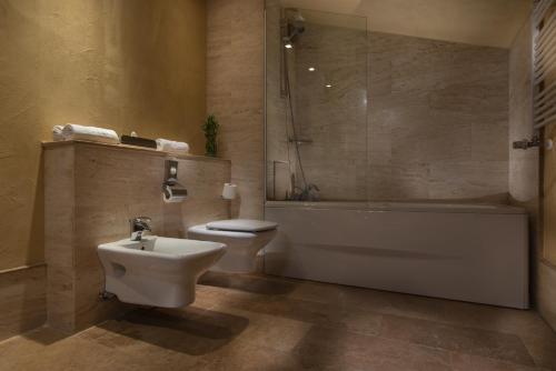 a bathroom with a tub and a toilet and a sink at Rosslyn Thracia Hotel Sofia in Sofia