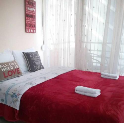 a bedroom with a red bed with two towels on it at Nice & Quiet Apartment in Best Area in Alexandroupoli
