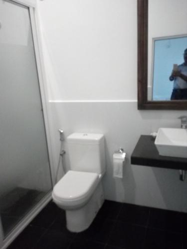 a bathroom with a toilet and a sink and a mirror at river edge bungalow in Matale