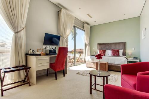 a bedroom with a bed and a desk with a tv at The One 8 Hotel in Cape Town