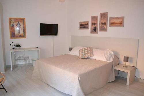 Un dormitorio con una cama y un televisor en la pared. en Le camere del Corso, en San Remo
