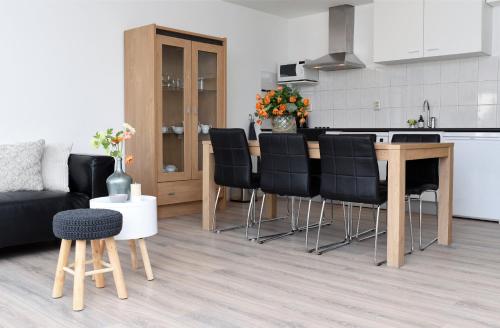 a kitchen and living room with a table and chairs at Residence Le Mistral in Noordwijk aan Zee
