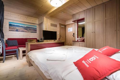 a bedroom with a large bed and a tv at Hotel Björnson & Björnson TREE HOUSES Jasná in Demanovska Dolina