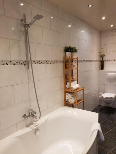 a white bathroom with a tub and a toilet at Hotel Grand Canal in Delft