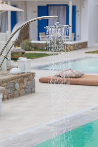 a water fountain in a swimming pool at Kostantis Summer Villas and Suites in Ornos