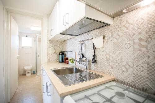 a kitchen with a sink and a counter top at Sunset Holiday House in Torre Lapillo