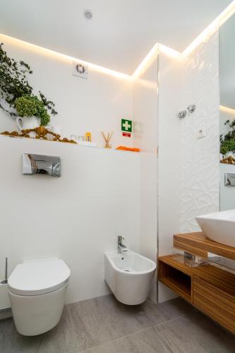a white bathroom with a toilet and a sink at The Explorers Home - Sunny Stylish Family-Friendly Apartment in Lisbon