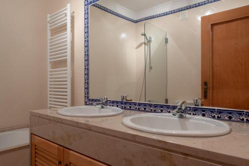 カザル・ダ・ラゴア・セッカにあるStunning Caravelas Apartmentのバスルーム(洗面台2台、鏡付)