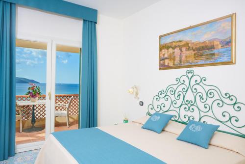sypialnia z łóżkiem i widokiem na ocean w obiekcie Hotel Biodola w mieście Portoferraio