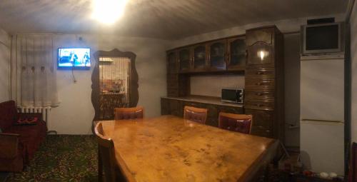 a kitchen with a wooden table in a room at Guest House Eles in Karakol
