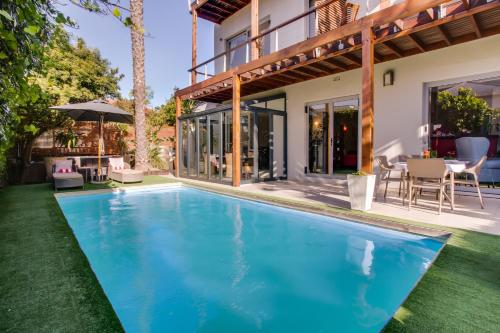 an image of a swimming pool in front of a house at The One 8 Hotel in Green Point - Solar Power in Cape Town