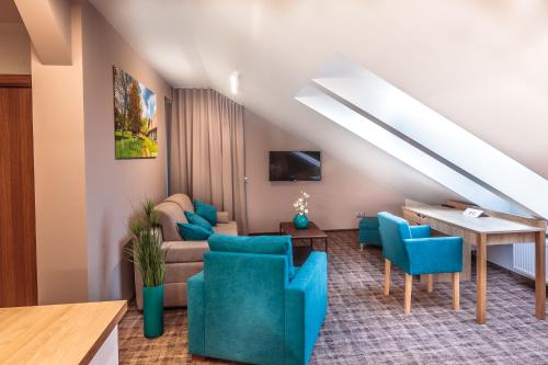 a living room with blue chairs and a couch at SOLAVO HOME&TRAVEL in Solec-Zdrój