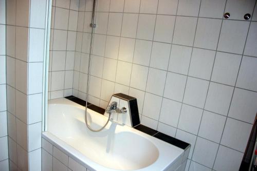 a white bathroom with a sink and a shower at GoWatt in Friedrichskoog