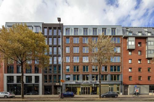 un grand bâtiment dans une rue avec des arbres et des voitures dans l'établissement Monet Garden Hotel Amsterdam, à Amsterdam