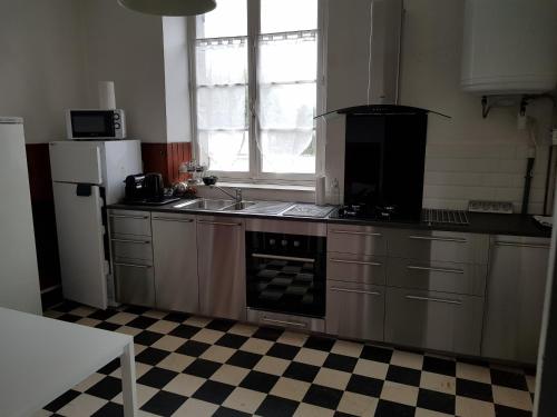 a kitchen with a stove and a sink and a refrigerator at Saint-Ay sur la route des châteaux in Saint-Ay