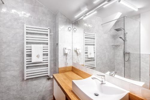 a white bathroom with a sink and a shower at SOLAVO HOME&TRAVEL in Solec-Zdrój