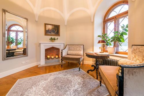 a living room with a fireplace and a chair at Schloss Fall, Keila-Joa in Keila-Joa