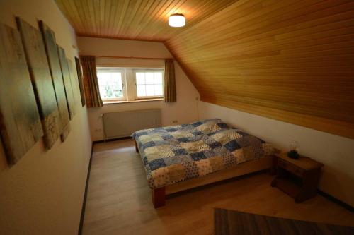 a small bedroom with a bed and a window at Ferienhaus Familie Martens in Sittensen