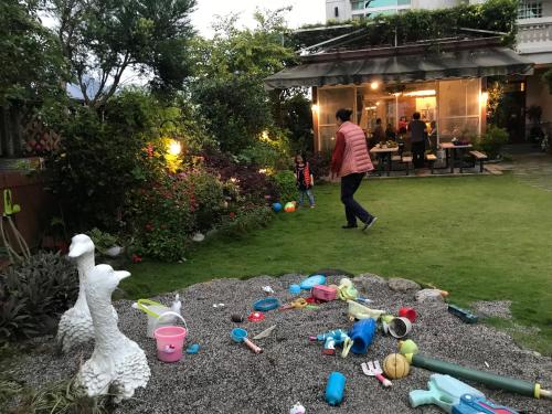 a woman walking through a pile of toys in a yard at 花蓮 達芙妮花園民宿 in Jian