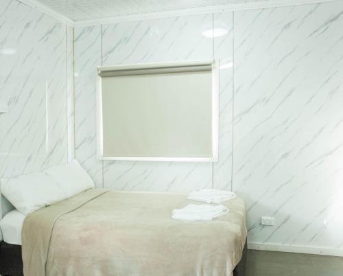 a white room with a bed and a window at Bellhaven Park in Heatherbrae