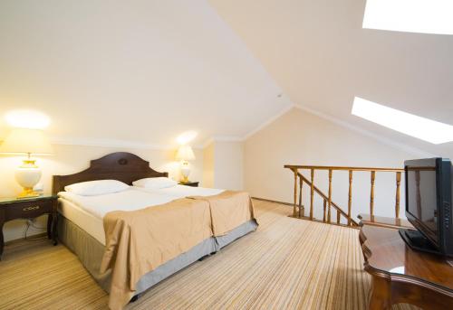 a bedroom with a large bed and a television at Optima Collection Medievale Lviv in Lviv