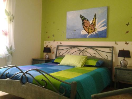 a bedroom with a bed with a butterfly painting on the wall at Azores Residence in Pesqueiro