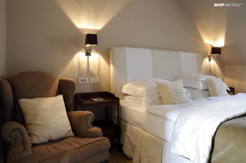 a hotel room with a bed and a chair at Lesar Hotel Angel - Member of Hip Hotels in Ljubljana