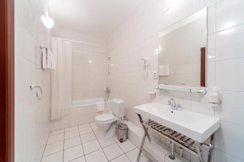 Baño blanco con lavabo y aseo en Na Dvoryanskoy Hotel, en Samara