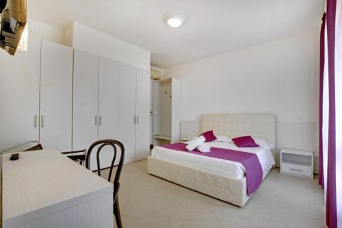 a bedroom with a bed with pink pillows and a desk at Fenix La Bohéme in Venice