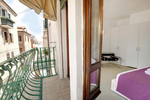 a room with a balcony with a bed and a balcony at Fenix La Bohéme in Venice