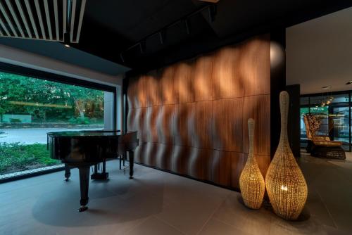 a living room with a piano and a table at Donautica Hotel & Restaurant in Fadd-Dombori