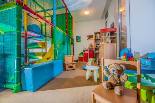 a teddy bear sitting on a table in a play room at Residence Hotel Balaton in Siófok