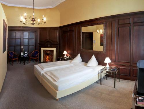ein großes Schlafzimmer mit einem großen Bett und einem Kamin in der Unterkunft Hotel Vivaldi Berlin am Kurfürstendamm in Berlin