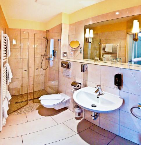 ベルリンにあるホテル ヴィヴァルディ ベルリン クアフュルステンダムの洗面台、シャワー、トイレ付きのバスルーム