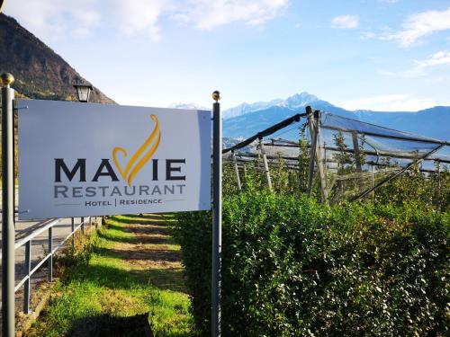 a sign for the maye restaurant with mountains in the background at Hotel Residence MaVie in Lagundo