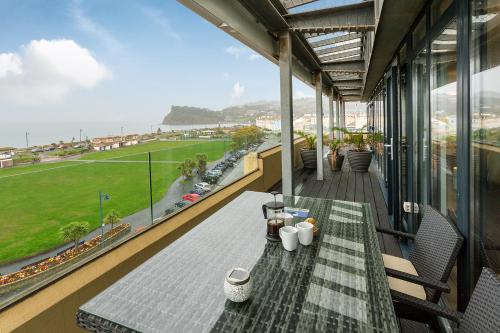 a balcony with a table and a view of a street at Riviera Apartments - Five Stylish Penthouse Apartments with Unrivalled Sea Views of Teignmouth, Shaldon, The Jurassic Coastline & The Teign Estuary in Teignmouth