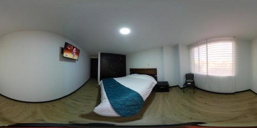 een slaapkamer met een bed in een kamer met een raam bij Hotel Florida ApartaSuites. in Ipiales