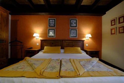 a bedroom with a large bed with yellow pillows at Hotel Pradas Ordesa in Broto