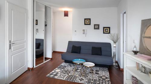 sala de estar con sofá azul y mesa en Le Marengo: Charmant, Rénové, Terrasse, Parking privé, en Toulouse