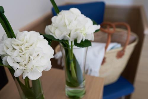 two white flowers in a glass vase on a table at Jesolopalace Hotel & Aparthotel in Lido di Jesolo