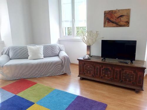 ein Wohnzimmer mit einem Sofa und einem Flachbild-TV in der Unterkunft Casa vacanze "Borahall" in Triest