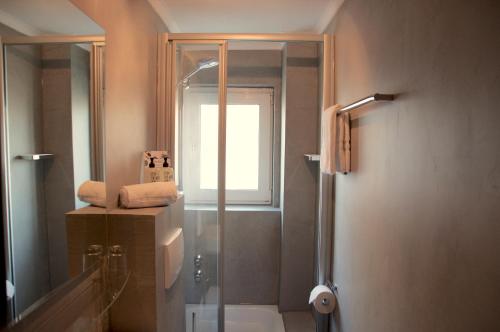 a bathroom with a shower and a toilet and a window at Lieblingsplatz Hotel Strandperle in Travemünde
