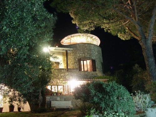 パッシニャーノ・スル・トラジメーノにあるELIO e DONYの円窓と木のある石造りの家