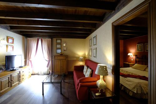 a bedroom with a bed and a couch and a television at Hotel Pradas Ordesa in Broto