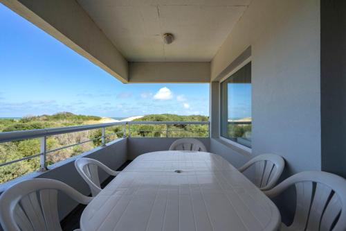 a white table and chairs on the balcony of a house at Valeria Playa Apart in Valeria del Mar